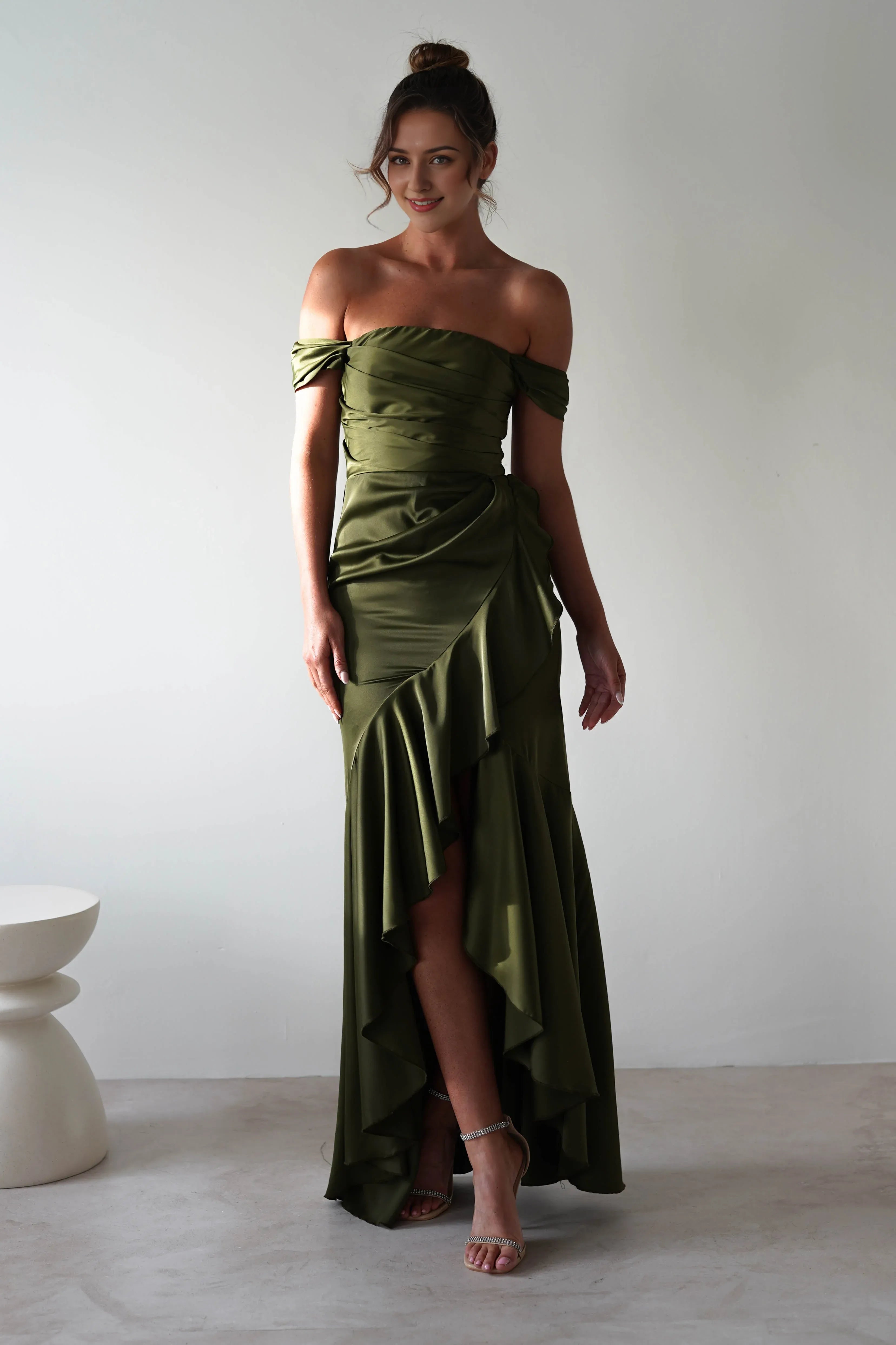 Vestido Weitese de satén verde oliva con escote en V, corpiño fruncido, falda asimétrica y dobladillo hasta el suelo.
